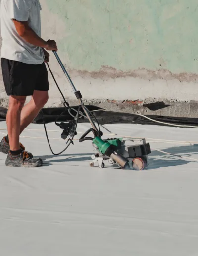 A man is working on a white roof.