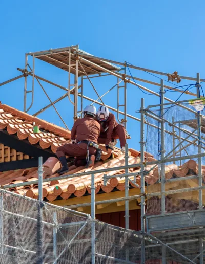 A man is working on a roof with scaffolding.