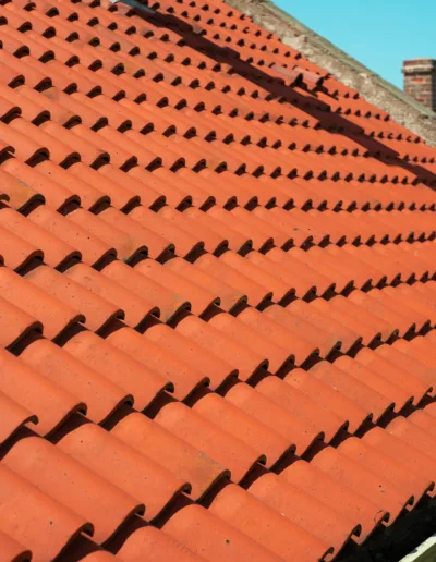 A red tiled roof with chimneys on it.
